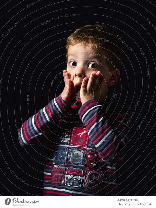 Surprised boy looking at camera over black background Joy Happy Face Child Human being Boy (child) Man Adults Infancy Mouth Arm Hand Stripe Stand Authentic Dark