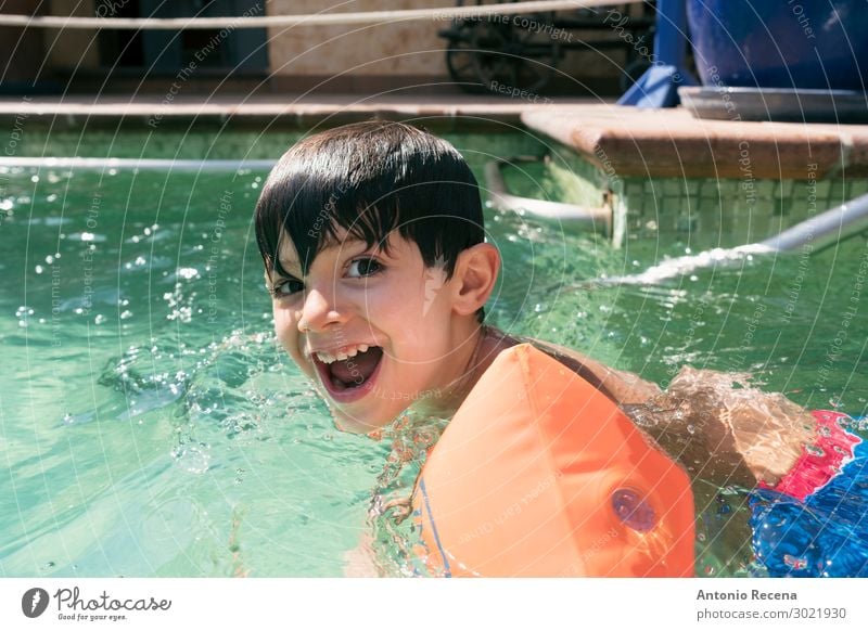 Smiling brunette kid with arm floats laughs Joy Happy Swimming pool Leisure and hobbies Child Human being Boy (child) Man Adults Infancy Arm Brunette Small Wet