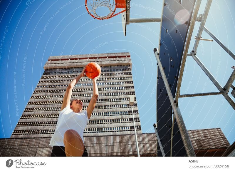 Girl playing basketball outdoors in the city Lifestyle Joy Beautiful Playing Summer Sports Woman Adults Youth (Young adults) Sky Park High-rise Building Street