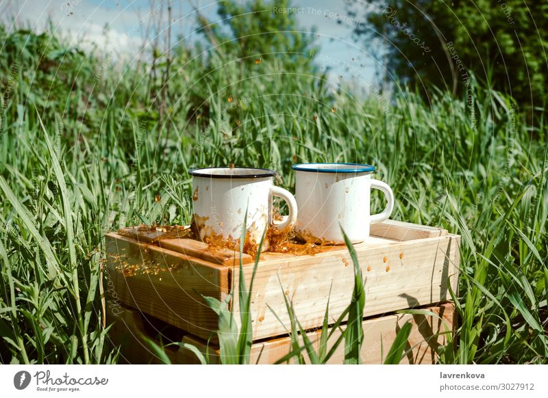 enamel mugs with coffee or tea on a wooden box Spring Grass Tea Exterior shot Beverage Drinking Wood Splashing Hot Cup Enamel Coffee Picnic Hiking Summer Nature