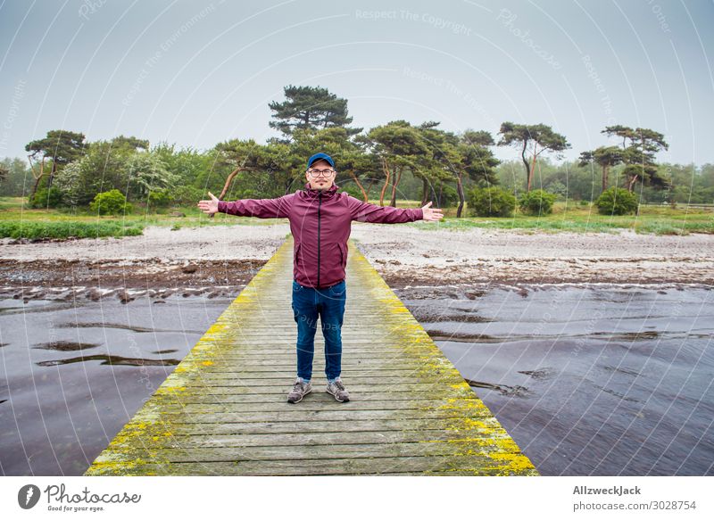young man in a wine-red rain jacket on a jetty Sweden Baltic Sea Coast Maritime Clouds Drizzle Vacation & Travel Vacation destination Vacation photo Relaxation