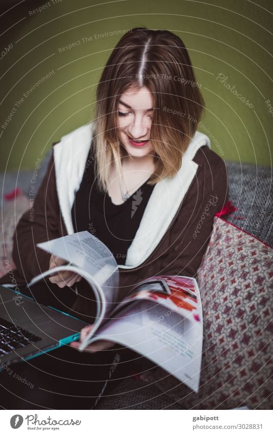 young woman flicks through newspaper Style Relaxation Living or residing Flat (apartment) Living room Human being Feminine Young woman Youth (Young adults) Life