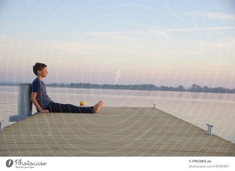 Boy chilling on jetty by lake Human being Masculine Boy (child) 1 13 - 18 years Youth (Young adults) Water Sky Sunrise Sunset Sunlight Beach Lake T-shirt Pants