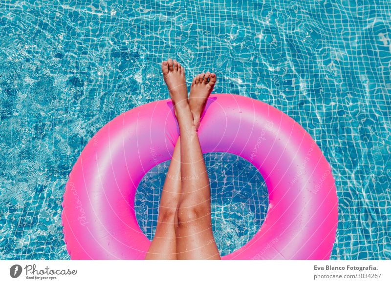 unrecognizable teenager girl floating on pink donuts in a pool Lifestyle Joy Happy Beautiful Relaxation Swimming pool Leisure and hobbies Vacation & Travel
