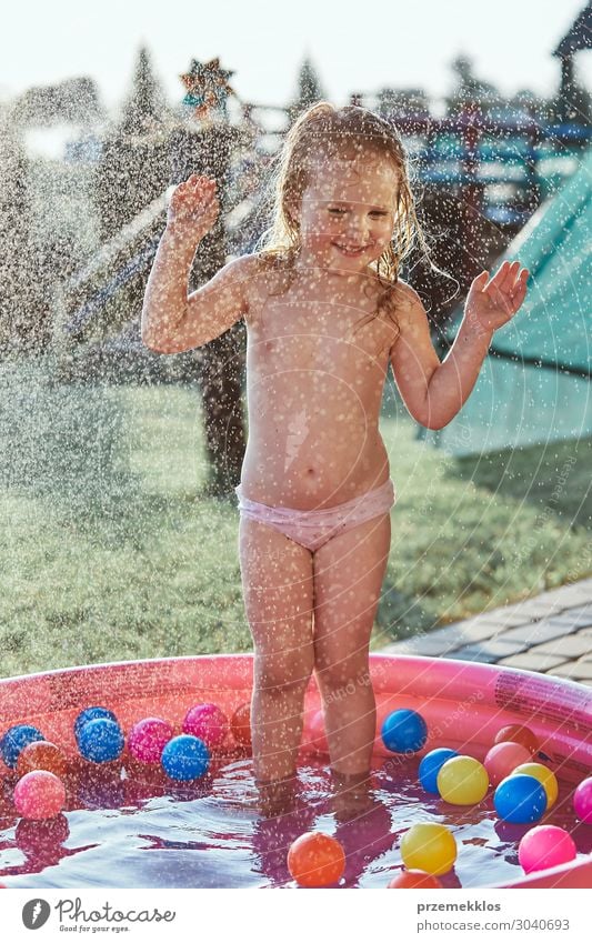Little girls enjoying a cool water sprayed by their father Lifestyle Joy Happy Relaxation Swimming pool Vacation & Travel Summer Garden Child Girl