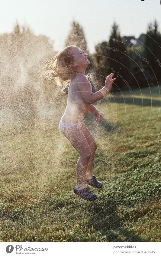 Little girl enjoying a cool water sprayed by her mother Lifestyle Joy Happy Vacation & Travel Summer Summer vacation Garden Child Human being Girl