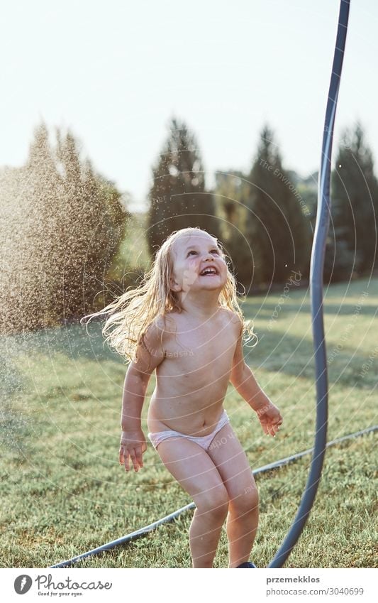 Little girl enjoying a cool water sprayed by her mother Lifestyle Joy Happy Vacation & Travel Summer Summer vacation Garden Child Girl Family & Relations