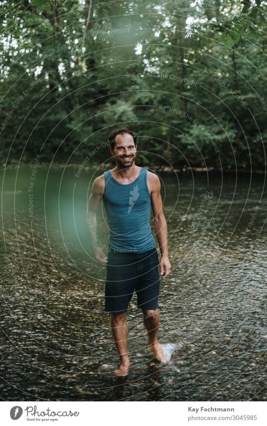 happy man wading through the water of a river 30s adult beard carefree casual caucasian cheerful confidence confident cool creative european freedom guy