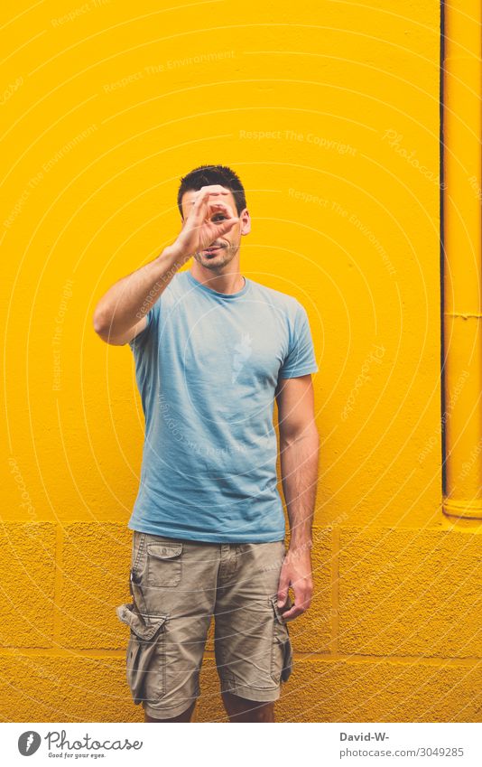 young man forms in front of a yellow wall the sign for excellent Man superb Sign by hand Looking accurate Perfect Expression Sign Language Correct Positive
