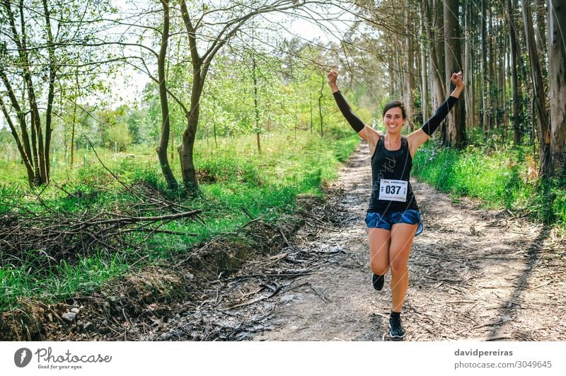 Young woman winning trail race Lifestyle Happy Feasts & Celebrations Sports Success Human being Woman Adults Nature Tree Forest Lanes & trails Sneakers Fitness