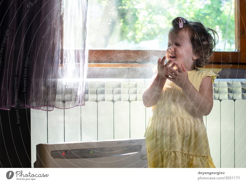 Little girl in a dusty room. Air purifier and coughing kid. Health care Child Infancy Earth Fresh Clean alergy allergen fine dust Sneezing sternutation air Home
