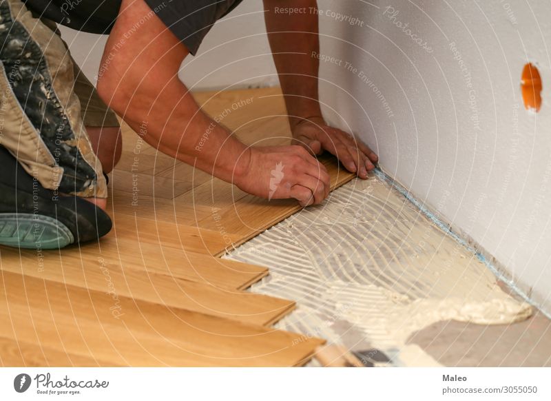 Craftsman lays parquet flooring Parquet floor Ground Floor covering Sheepish Installations Construction site Working man Joiner Craftsperson Laminate Panels