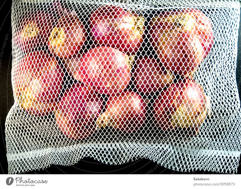 Red onions in mesh bag isolated on black background Vegetable Herbs and spices Organic produce Packaging Package Plastic packaging Sack Natural Dry Black Onion