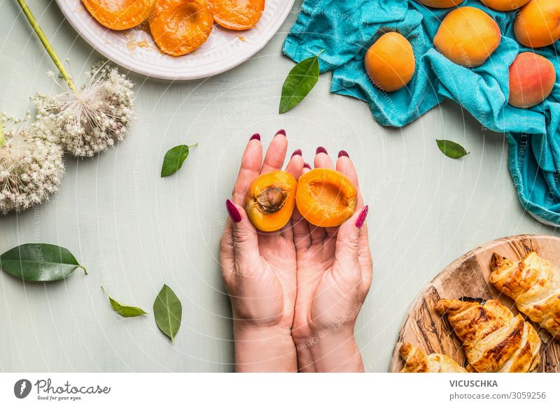 Hands holding halved apricot with pit Food Fruit Croissant Nutrition Crockery Style Human being Woman Adults Design Apricot Division Kernels & Pits & Stones