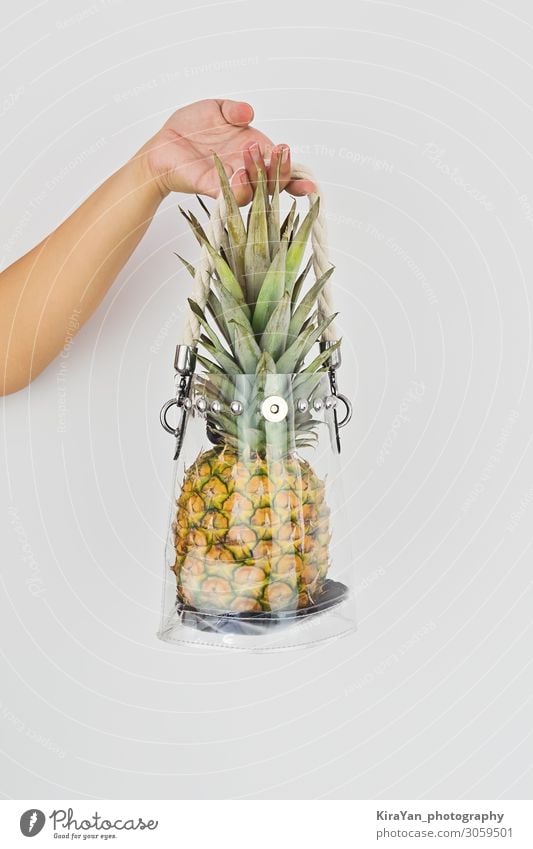 Hand holding fresh ripe pineapple in transparent plastic bag Lifestyle Shopping Style Leisure and hobbies Vacation & Travel Summer Fingers Fashion Plastic bag