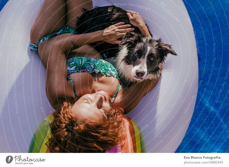 young woman and her border collie dog standing on an inflatable toy unicorn at the swimming pool. Summertime, fun and lifestyle outdoors Breed Black
