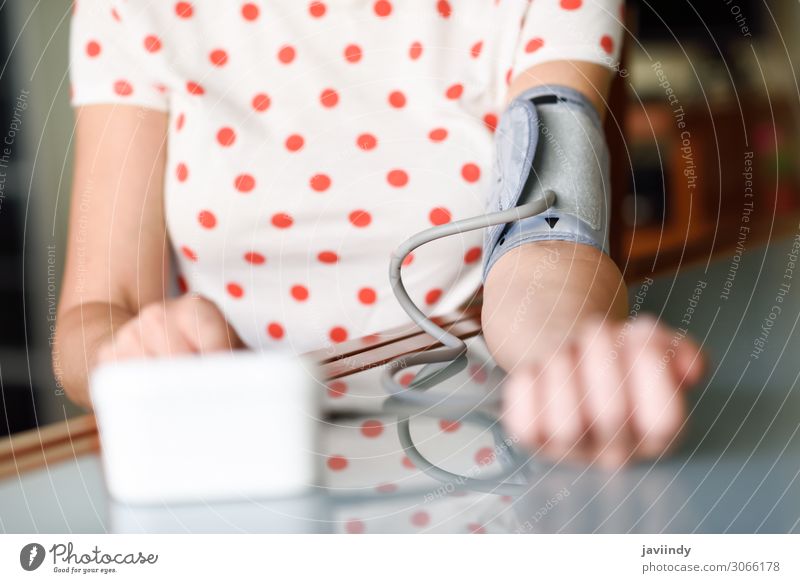 Woman measuring her own blood pressure at home. Health care Illness Medication Examinations and Tests Screen Tool Human being Adults Arm 1 30 - 45 years