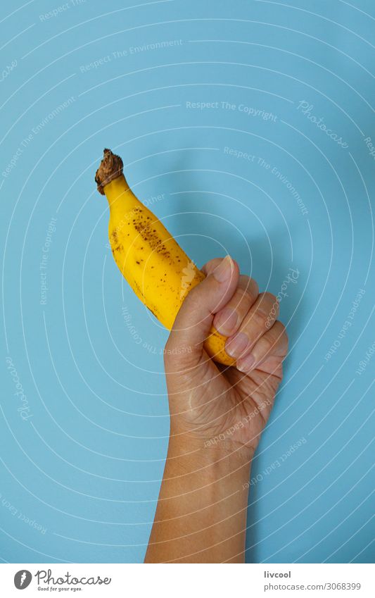 banana on blue wall II Food Vegetable Fruit Nutrition Lifestyle Design Human being Woman Adults Arm Hand Fingers Nature To enjoy Fresh Healthy Delicious Blue
