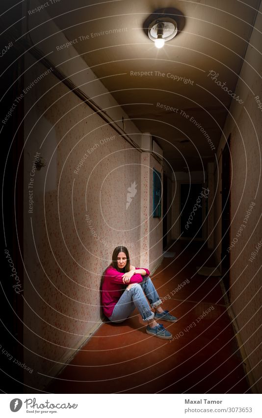 Sad and desperate woman sits in a dark corridor Woman Adults Sit Sadness Dark Emotions Concern Grief Loneliness Considerate abandonment Anxious bleakness casual