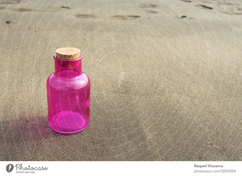 Pink glass bottle on the sand. Bottle Sand Summer Coast Beach Communicate Brown Loneliness Colour photo Exterior shot Copy Space right Sunlight