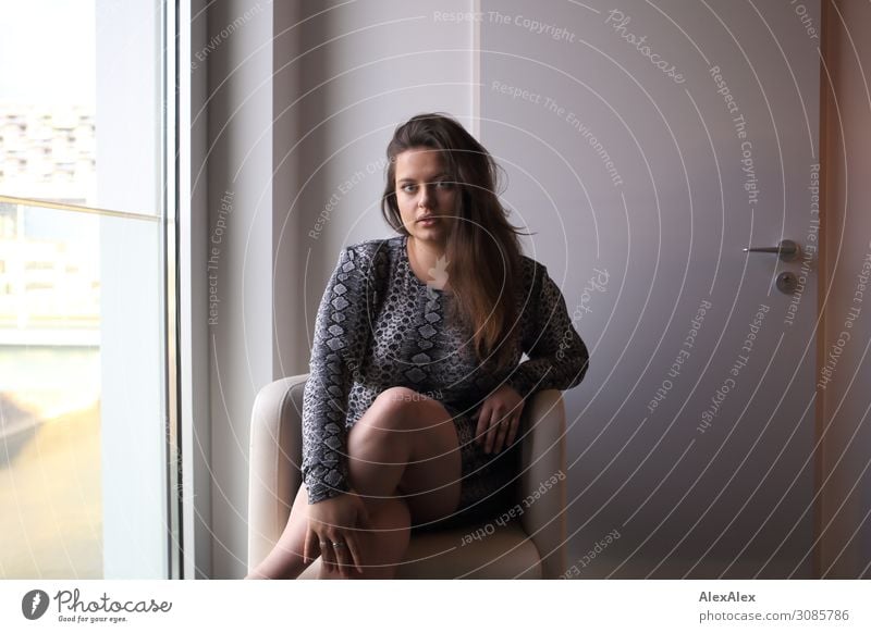 Portrait of a young woman in an armchair Lifestyle Elegant Style Beautiful Armchair Room Hotel room Young woman Youth (Young adults) 18 - 30 years Adults Window