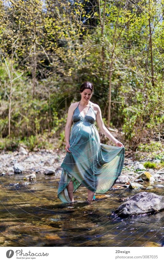 Pregnant girl posing near the river wearing a green dress. Lifestyle Style Joy Happy Beautiful Relaxation Freedom Summer Ocean Feminine Young woman