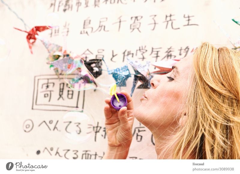 Blonde woman blowing soap bubbles in a park, San Sebastian Lifestyle Design Happy Relaxation Playing Rope Feminine Woman Adults Female senior Head
