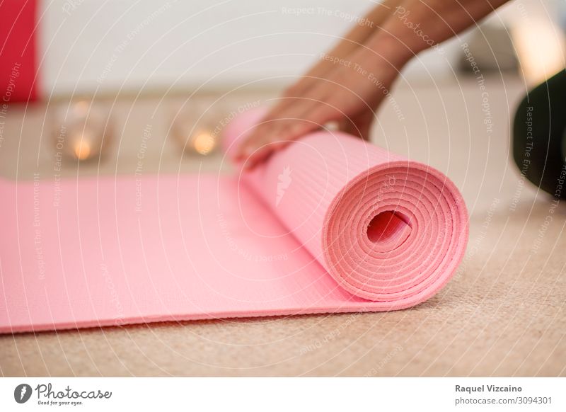 Woman hands winding the pink yoga mat. Lifestyle Wellness Relaxation Meditation Sports Yoga Hand Candle Breathe Healthy Brown Pink Peaceful Calm Contentment