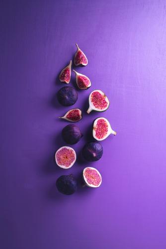 Fresh figs on a purple background. Sliced figs Vegetable Fruit Dessert Nutrition Vegetarian diet Diet Exotic Healthy Eating Delicious Juicy Violet Red