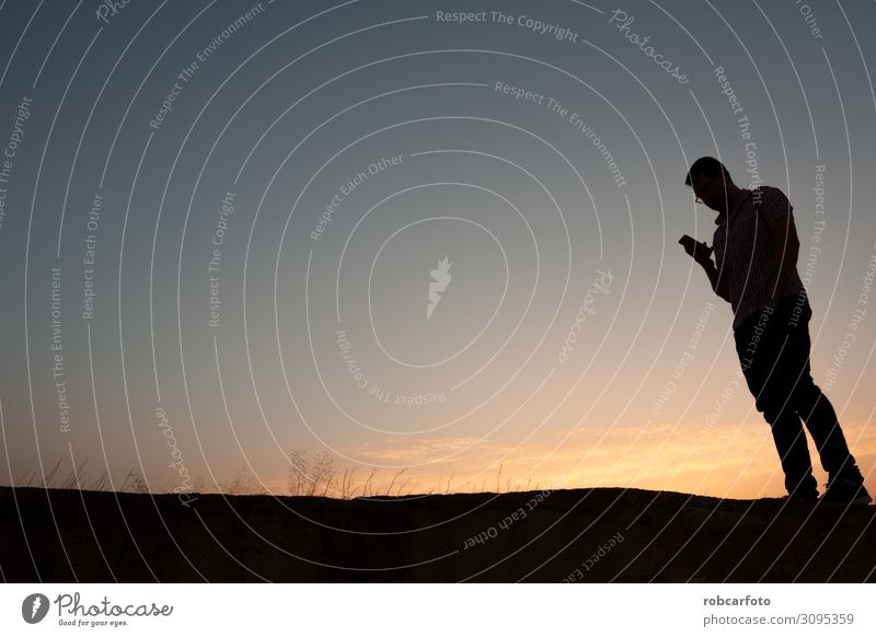 silhouette of man with cell phone at sunset Business To talk Telephone PDA Human being Man Adults Hand Stand To call someone (telephone) Dark Smart Black White