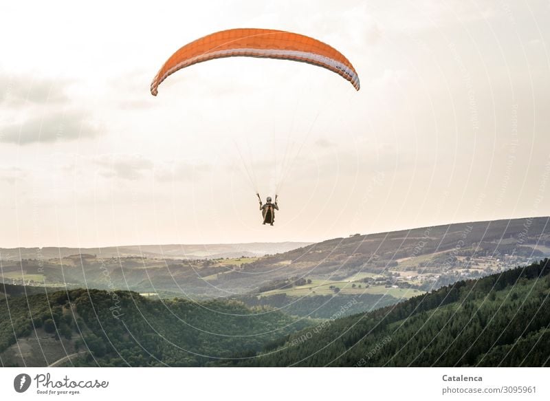 A paraglider glides silently over the hilly landscape Leisure and hobbies Sports Paragliding Androgynous 1 Human being Nature Landscape Sky Clouds Horizon