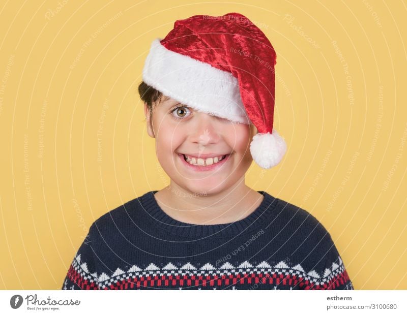 Child Wearing Christmas Santa Claus Hat on yellow background Lifestyle Joy Winter Feasts & Celebrations Christmas & Advent New Year's Eve Human being Masculine