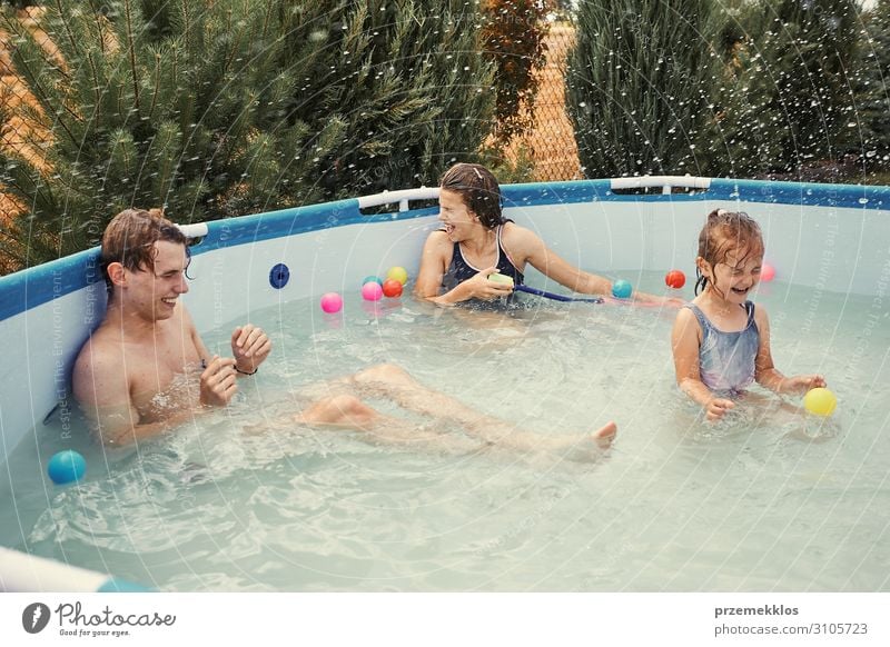 Children splashing in a pool Lifestyle Joy Happy Relaxation Swimming pool Playing Vacation & Travel Summer Summer vacation Girl Boy (child) Young man