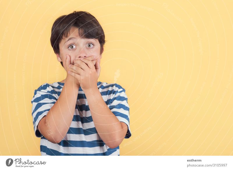 child covering her mouth by hands on yellow background Human being Masculine Mouth Arm Hand 1 8 - 13 years Child Infancy Movement To hold on Sadness Funny