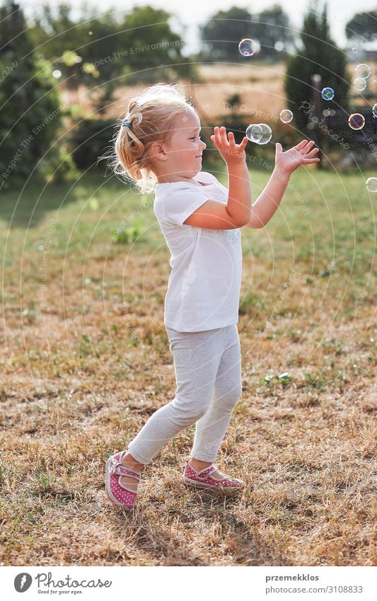 Little gir playing with soap bubbles Lifestyle Joy Happy Playing Garden Child Girl Infancy 1 Human being 30 - 45 years Adults Playground To enjoy Authentic