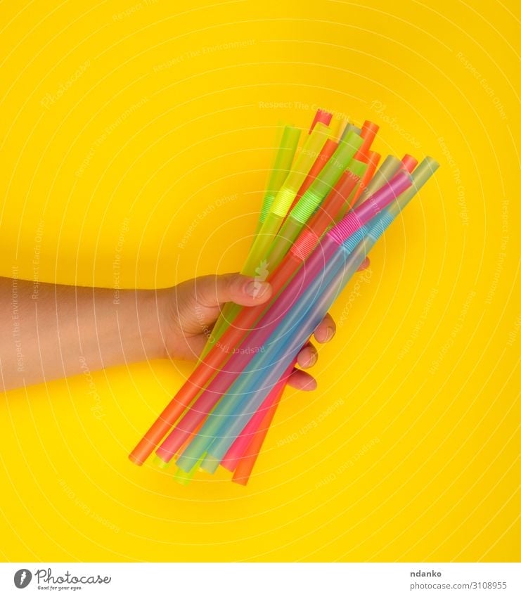 hand holding multicolored plastic cocktail tubes Beverage Juice Joy Body Arm Hand Tube Plastic Blue Yellow Green Pink Red White Flexible Colour bar Caucasian