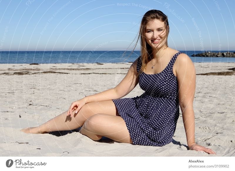 Young, tall woman sits in a summer dress on the beach of the Baltic Sea and smiles Style already Wellness Well-being Summer Summer vacation Sun Sunbathing Beach