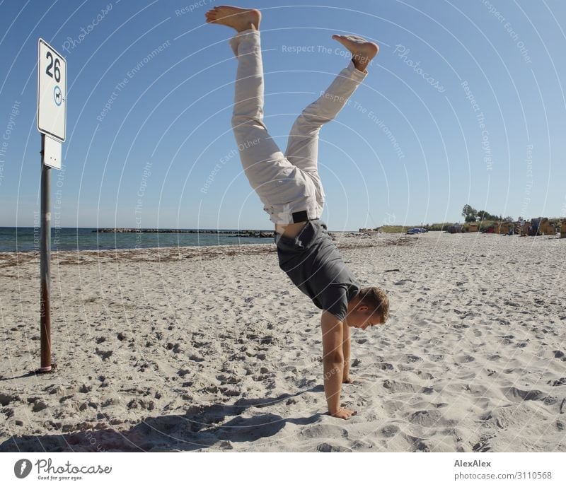 Young, sporty man does handstands on a beach Lifestyle Style Joy already Athletic Fitness Summer Summer vacation Sun Beach Ocean Track and Field Handstand