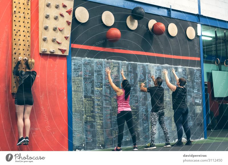 Group training at the box Lifestyle Sports Blackboard Human being Woman Adults Man Fitness Athletic Authentic Strong wall ball pegboard cross-training Gymnasium