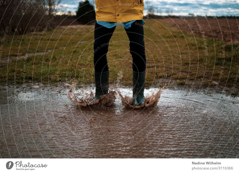 Kid jumping in a puddle Human being Feminine Child Girl Infancy Life Abdomen 1 8 - 13 years Nature Earth Water Clouds Bad weather Rain jacket Rubber boots Jump