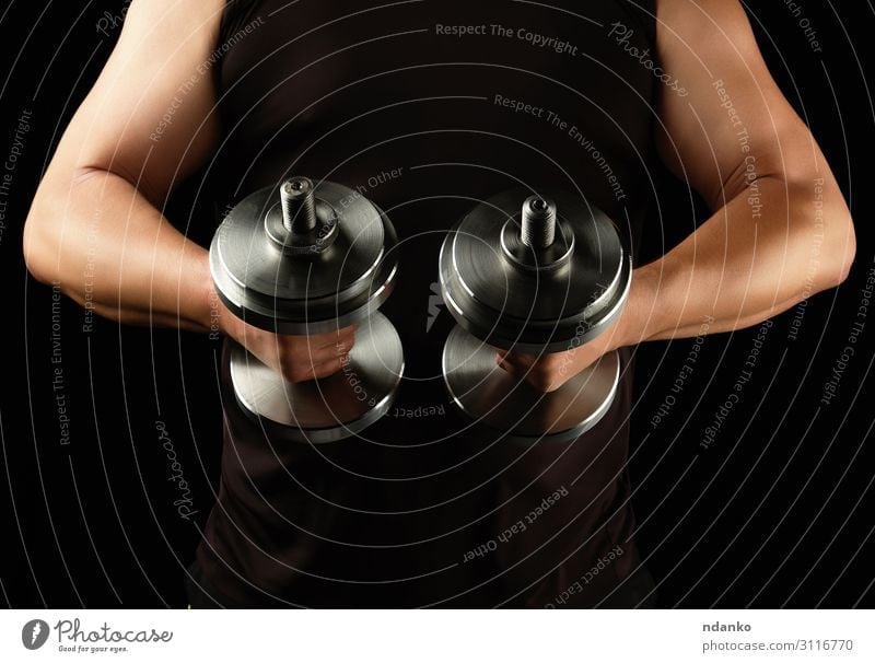 man in black clothes holds steel dumbbells Lifestyle Body Athletic Fitness Sports Human being Man Adults Arm Hand Steel Muscular Strong Black Power abdominal