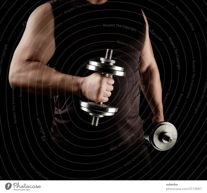 man in black clothes holds steel dumbbells Lifestyle Athletic Fitness Sports Track and Field Human being Man Adults Arm Hand 1 30 - 45 years Steel Stand