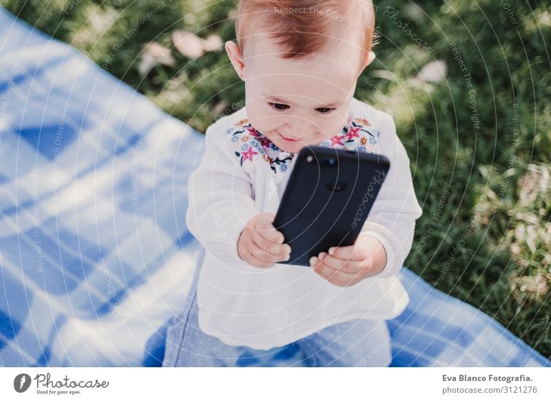 baby girl outdoors in a park using mobile phone Lifestyle Joy Beautiful Playing Summer Sun Parenting Child Cellphone PDA Screen Technology Internet Baby Girl