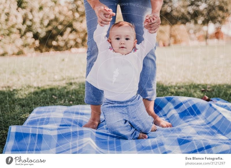 young mother playing with baby girl outdoors in a park Lifestyle Joy Beautiful Playing Summer Sun Parenting Child Feminine Baby Young woman Youth (Young adults)