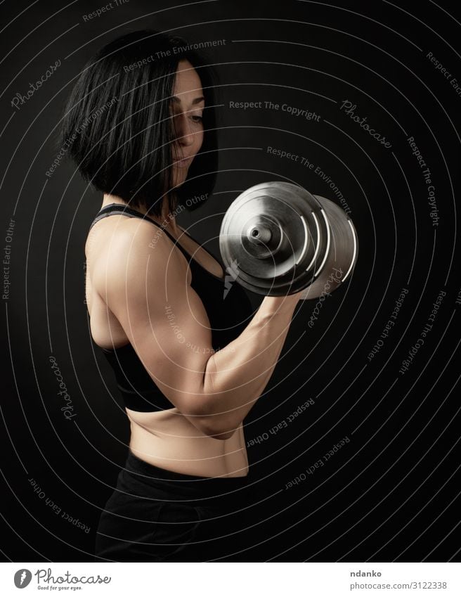 young woman holds steel type-setting dumbbells Lifestyle Body Athletic Fitness Sports Human being Woman Adults Hand Thin Muscular Strong Black Power Energy