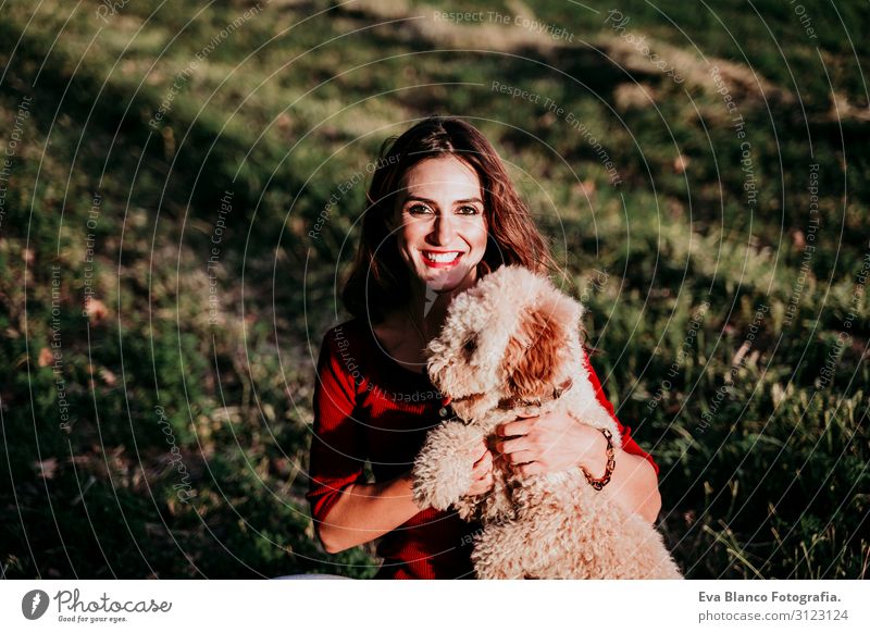 beautiful caucasian woman with her cute brown poodle dog at sunset in countryside. Pets and lifestyle outdoors Youth (Young adults) Woman Sunset Field Hat
