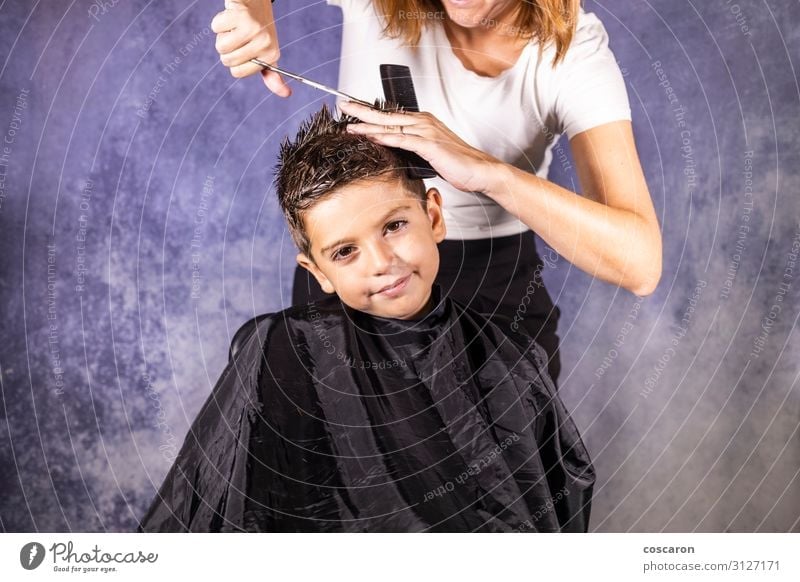 Beautiful boy getting a haircut with scissors Lifestyle Elegant Style Hair and hairstyles Child Work and employment Profession Workplace Business Scissors