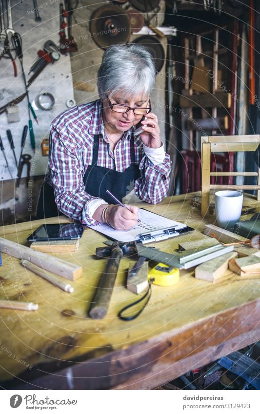 Senior female carpenter talking on the phone Craft (trade) Business To talk Hammer Human being Woman Adults Wood Old Authentic Carpenter senior mobile