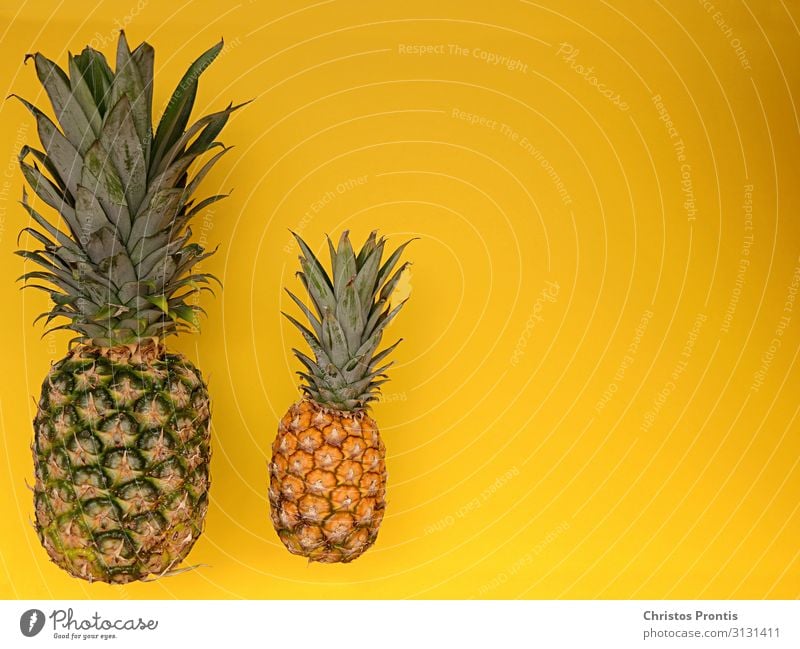 Pineapple with mini pineapple on a yellow ground. Food Fruit Dessert Eating Dinner Organic produce Diet Fitness Healthy Sweet Yellow Green Idea background