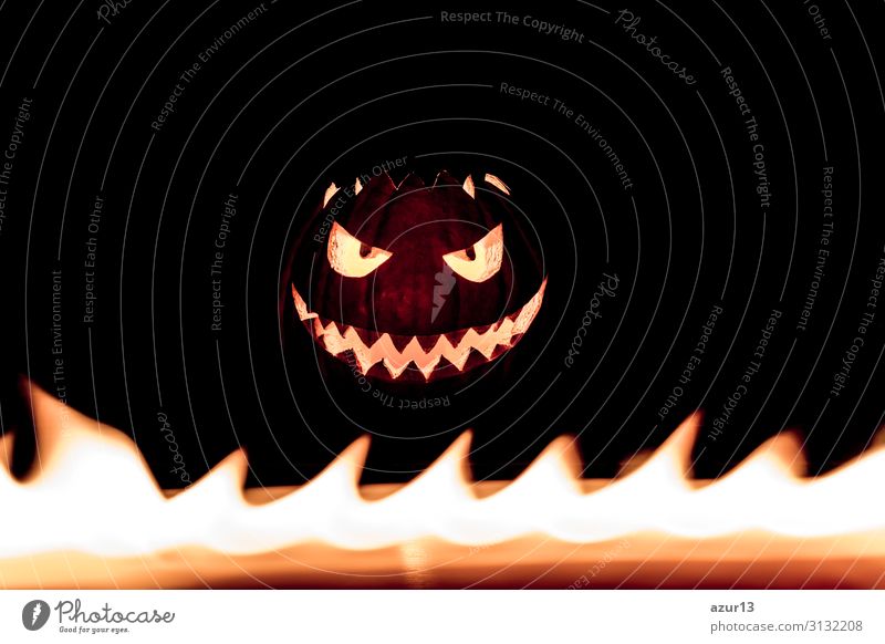 Carved spooky halloween pumpkin in hot burning bright fire flames Hallowe'en Creepy Bright Fear Blaze face candle autumn Symbols and metaphors carved Self-made